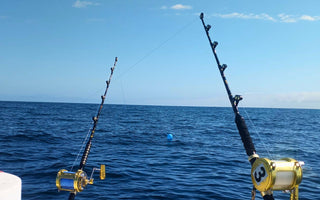 Heavy-duty deep sea fishing rod with reel on a boat deck
